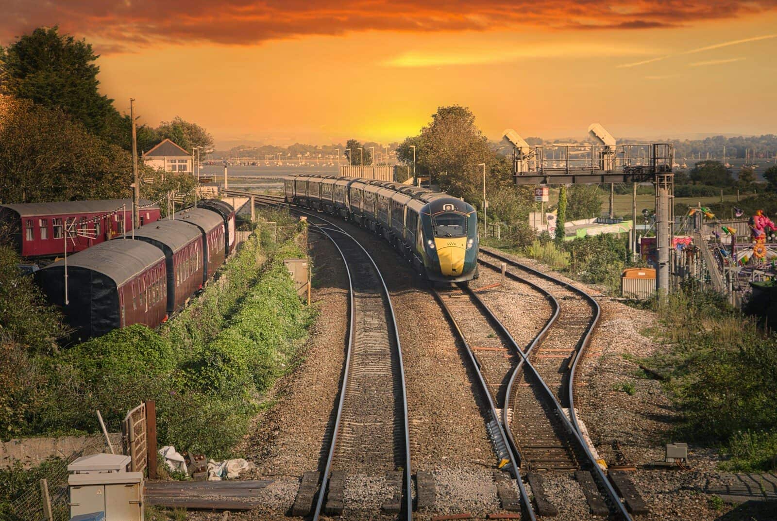 yellow and black train on rail tracks during sunset
